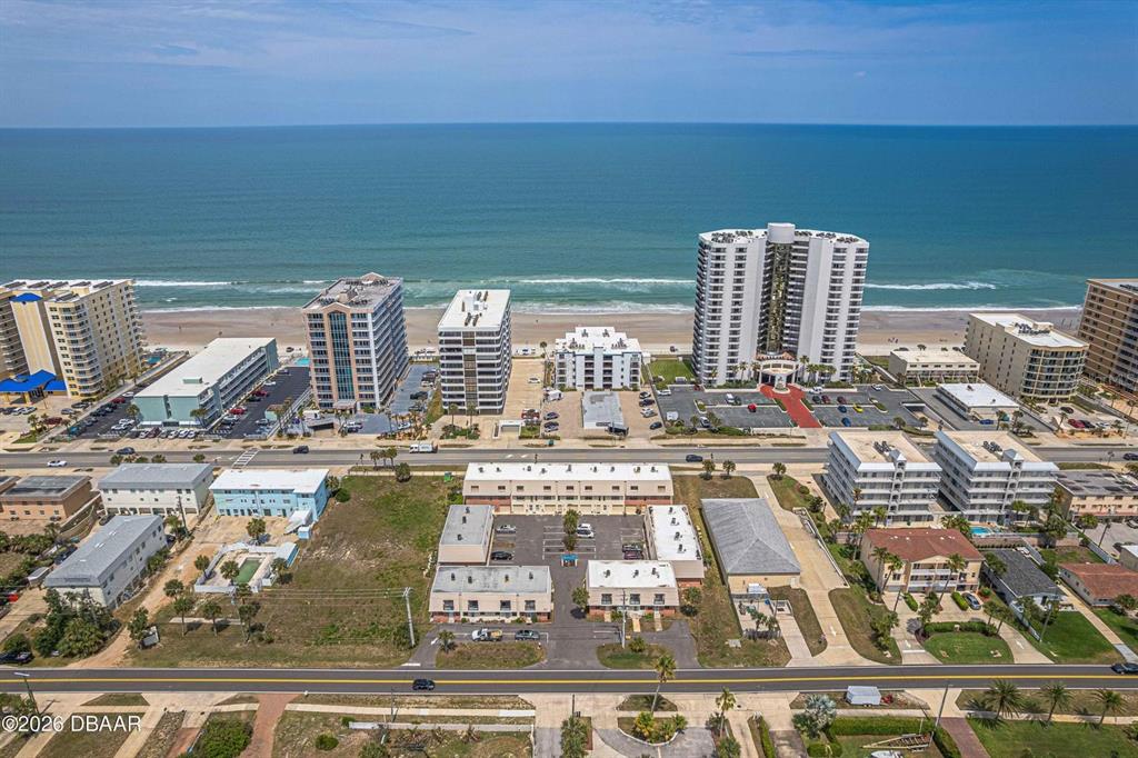An aerial view shows multiple beachfront high-rise buildings and parking lots along the coast — 3750 S ATLANTIC AVENUE UNIT 190, DAYTONA BEACH, FL