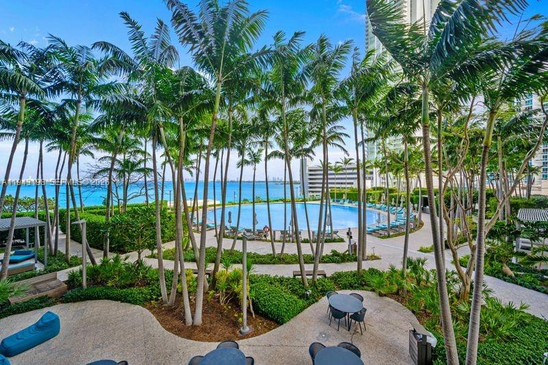 A swimming pool surrounded by palm trees overlooks the ocean from a resort-style patio — 650 NE 32nd St # 602, Miami FL 33137, MIAMI, FL