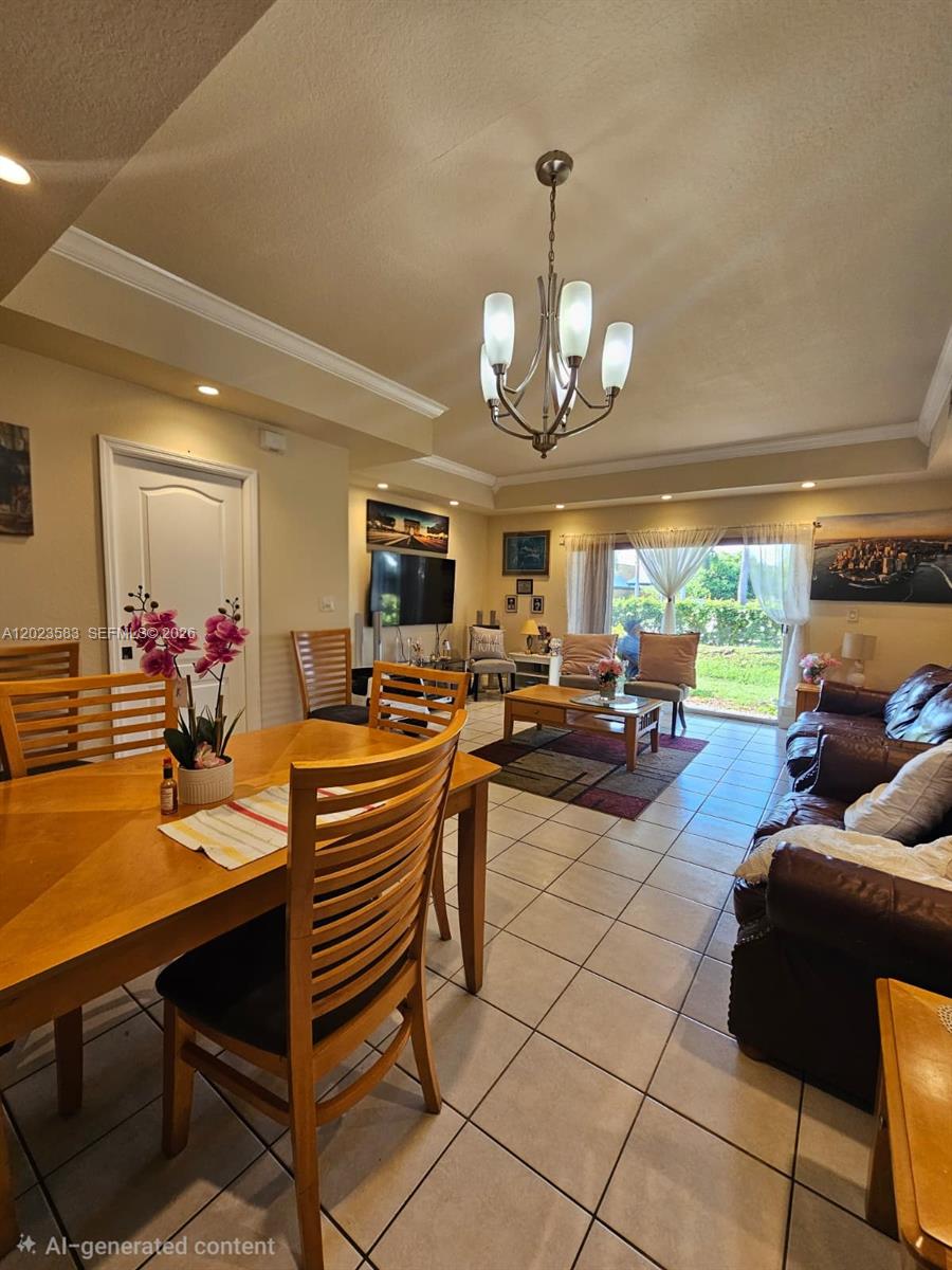 An open-concept living and dining area features tile flooring, a chandelier, and sliding glass doors — 8960 W Flagler St # 3, Miami FL 33174, MIAMI, FL