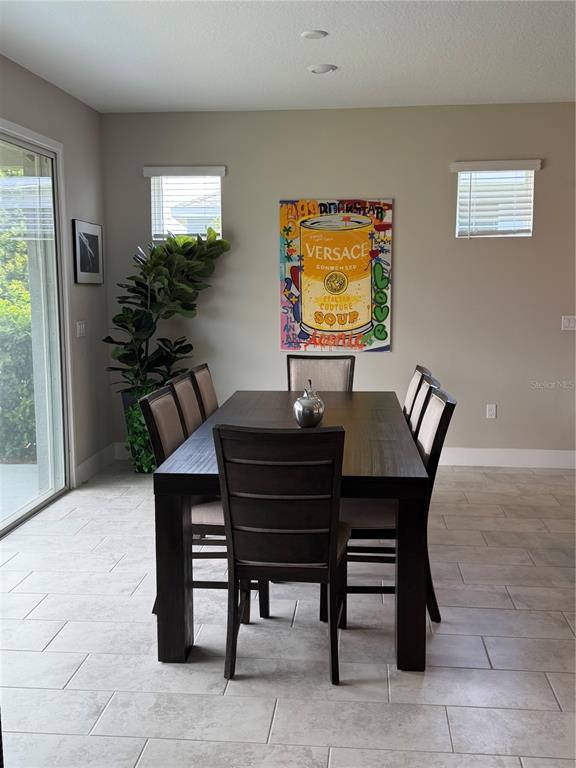 A dining room features a dark wood table, six chairs, and pop art wall decor — 4434 NW 54TH TERRACE, OCALA, FL