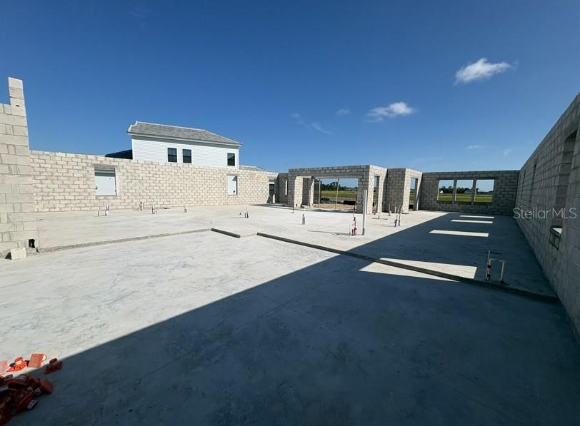 An unfinished concrete slab foundation with surrounding block walls under a clear blue sky — 10645 SPRING SAPLING CIRCLE, PARRISH, FL