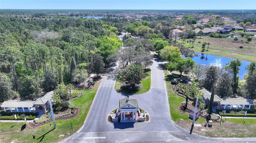 An aerial view of a gated community entrance with a guardhouse and landscaped grounds — 419 CHELSEA AVENUE, DAVENPORT, FL