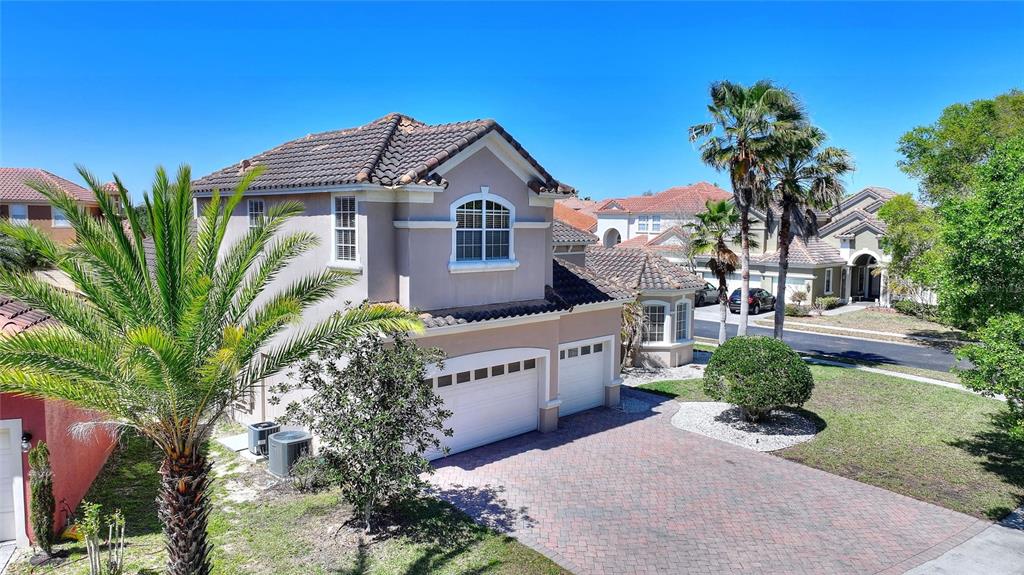 An aerial view of a two-story suburban house with a paved driveway and palm trees — 419 CHELSEA AVENUE, DAVENPORT, FL