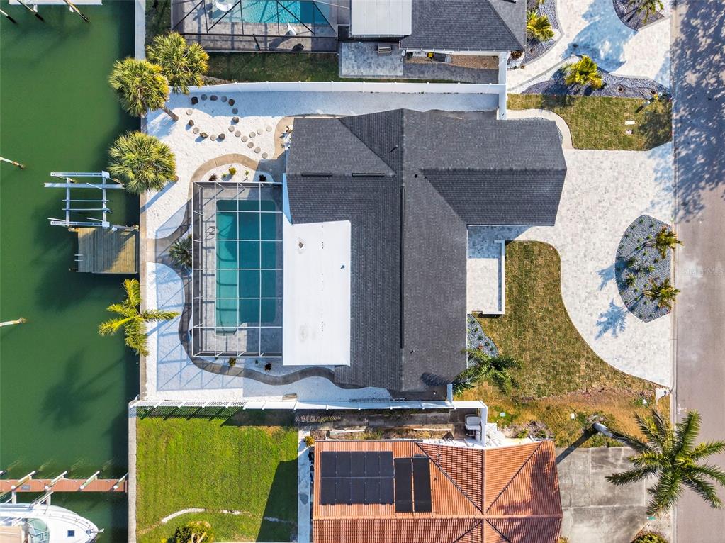 An aerial view shows a house with a dark roof, pool enclosure, and waterfront dock — 4426 43RD STREET S, ST PETERSBURG, FL
