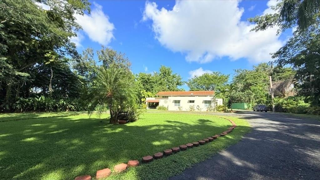 A single-story house with a red tile roof sits on a large, grassy lot — 177 VANDA STREET, GUAYNABO, PR