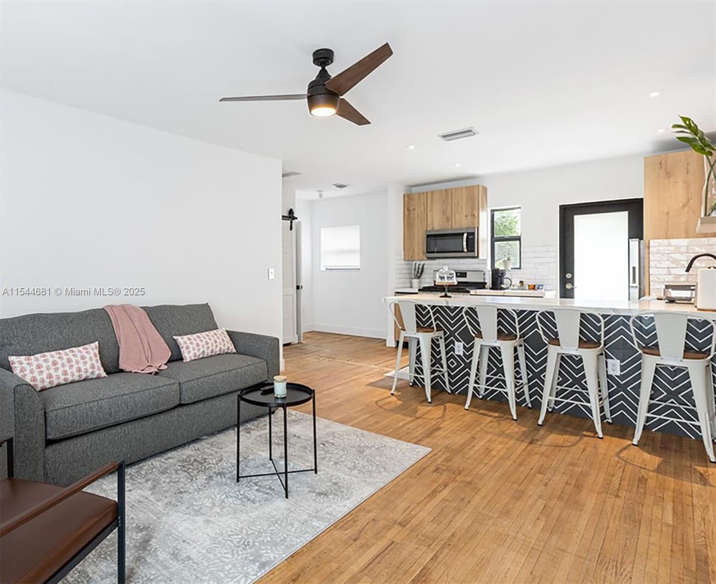 A living room with a grey sofa and a kitchen featuring a patterned island — 740 SW 9th St # 1, Miami FL 33130, MIAMI, FL