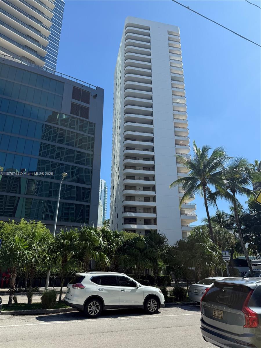 A tall white residential high-rise building stands next to a modern glass-facade structure — 151 SE 15th Rd # 2703, Miami FL 33129, MIAMI, FL