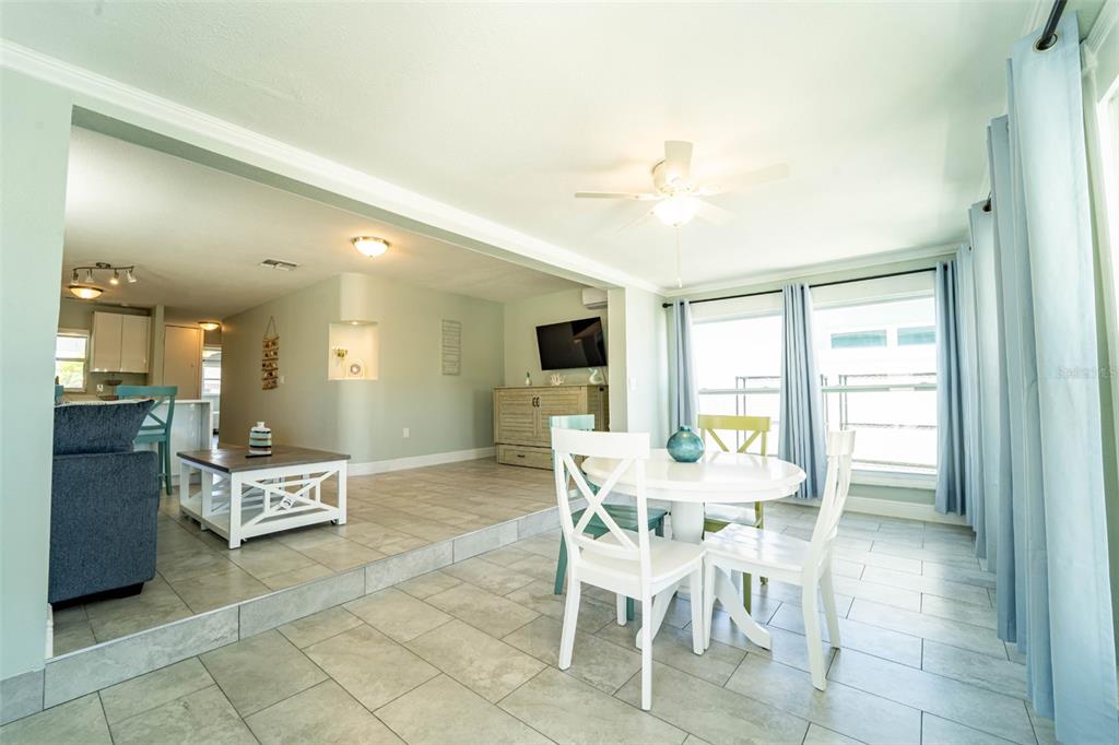A dining area with a white table and chairs sits next to a sunken living room — 4825 FLORAMAR TERRACE, NEW PORT RICHEY, FL