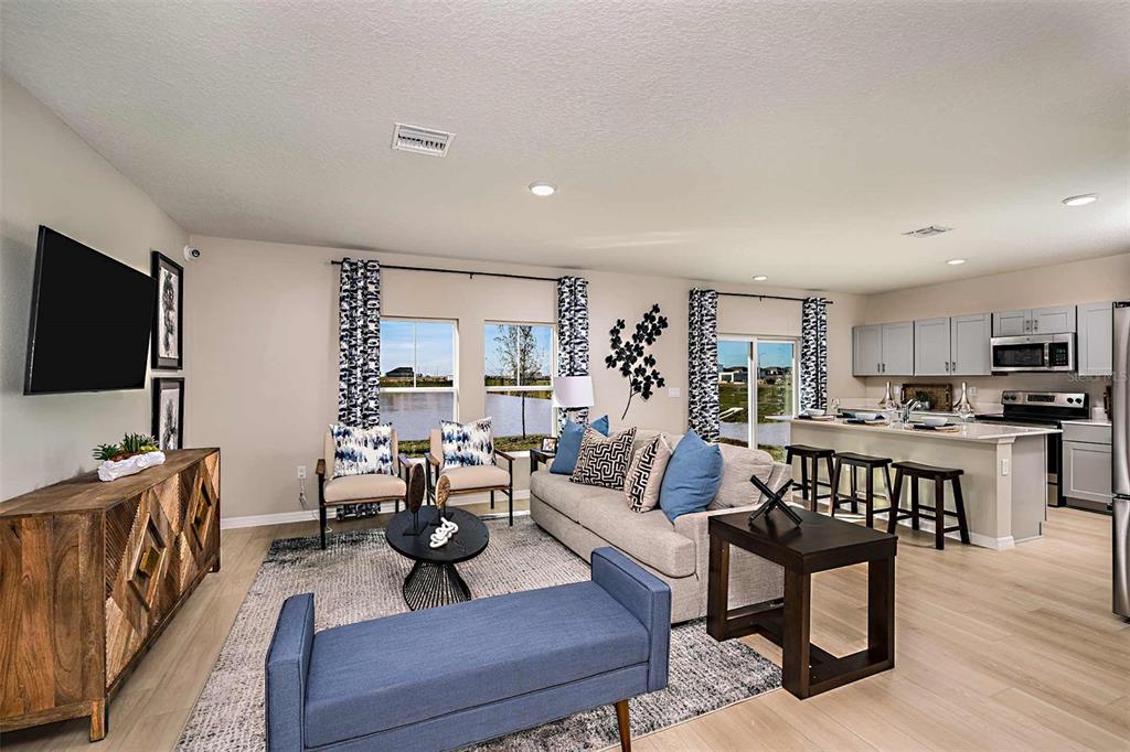 A living room and kitchen open floor plan with light wood floors and water views — 1723 VANILLA STREET, LAKE HAMILTON, FL