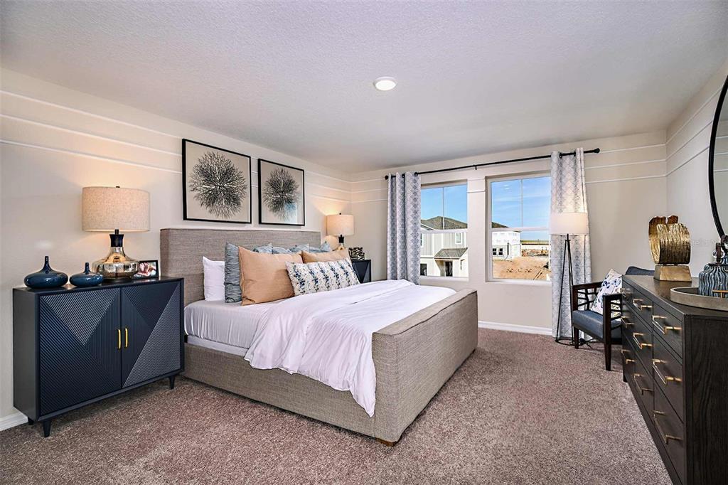 A bedroom features a gray upholstered bed, two nightstands, and two windows overlooking a construction site — 1723 VANILLA STREET, LAKE HAMILTON, FL