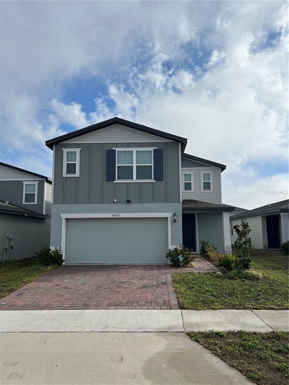 A two-story house with a gray exterior, a two-car garage, and a brick paver driveway — 4932 MAINSAIL STREET, HAINES CITY, FL