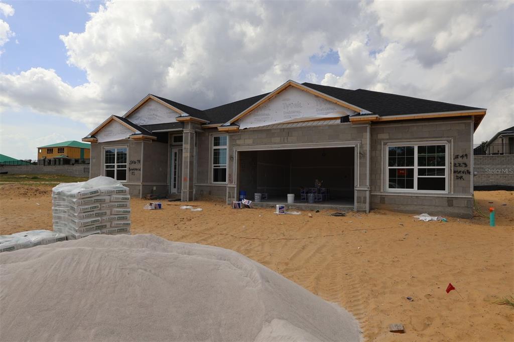 A kitchen under construction features white cabinets, a central island, and light wood flooring — 3223 ROSEVILLE DRIVE, APOPKA, FL