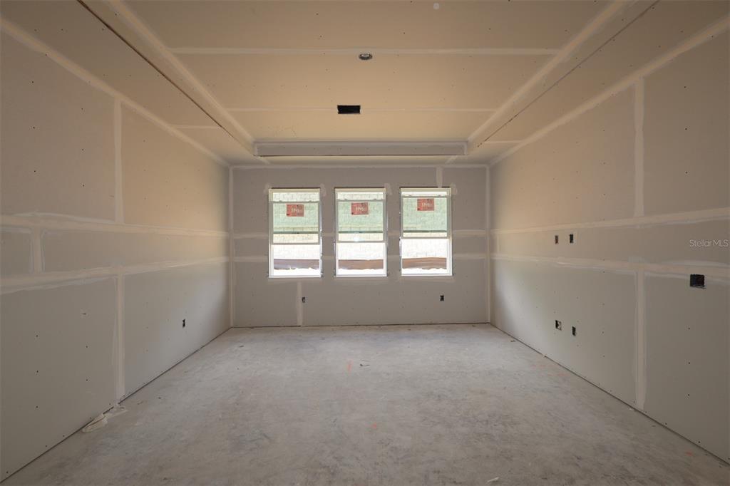 An empty room with beige walls, white trim, and an unfinished concrete floor — 3223 ROSEVILLE DRIVE, APOPKA, FL