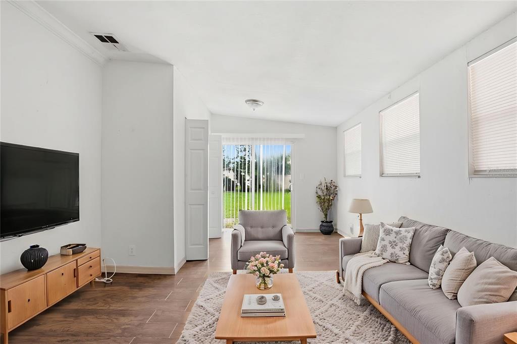 A living room features a grey sofa, an armchair, a wooden coffee table, and a television — 1510 E NAVAJO AVENUE, TAMPA, FL