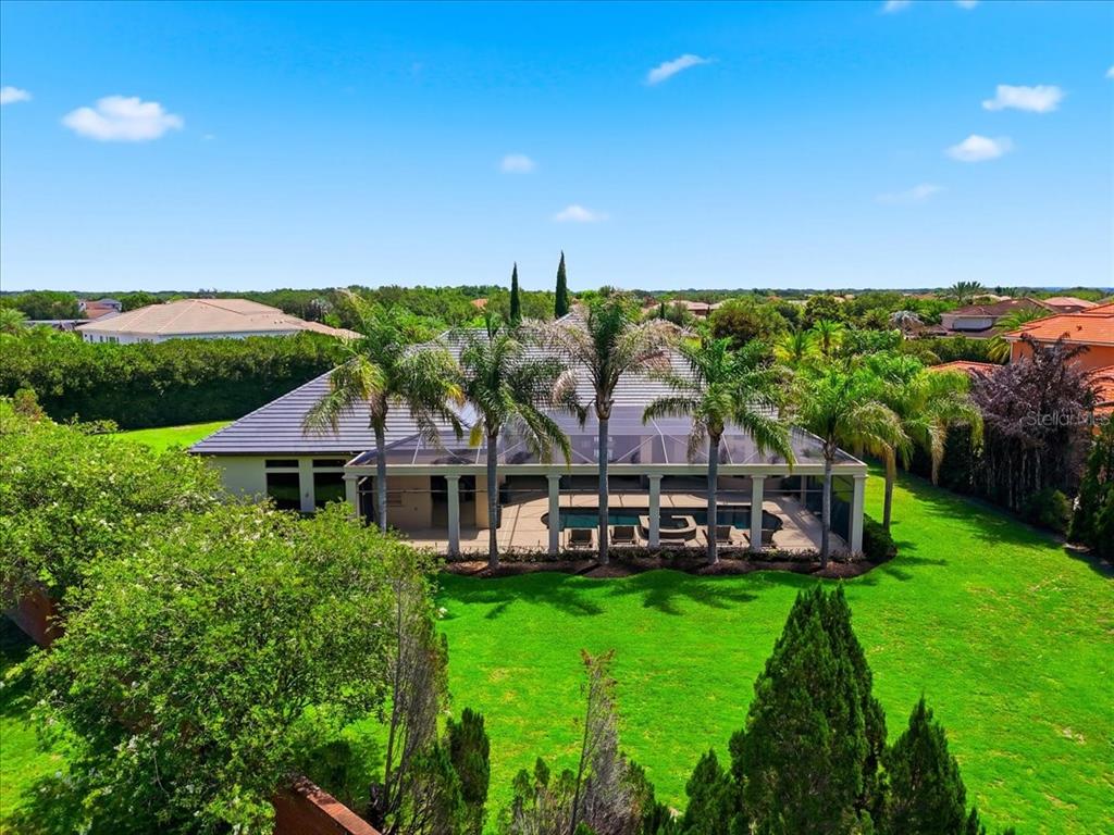 An aerial view of a house with a screened-in pool and palm trees in the backyard — 13431 BELLARIA CIRCLE, WINDERMERE, FL