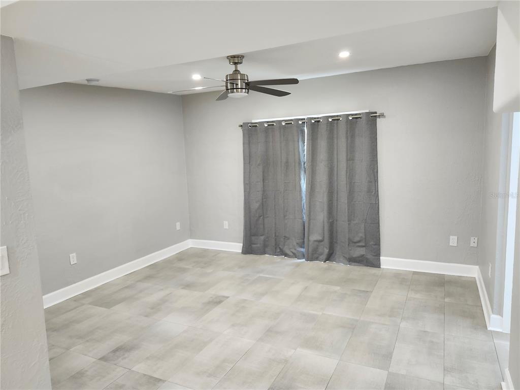 A room with gray walls, light tile flooring, a ceiling fan, and gray curtains — 5212 OLD CHENEY HIGHWAY, ORLANDO, FL