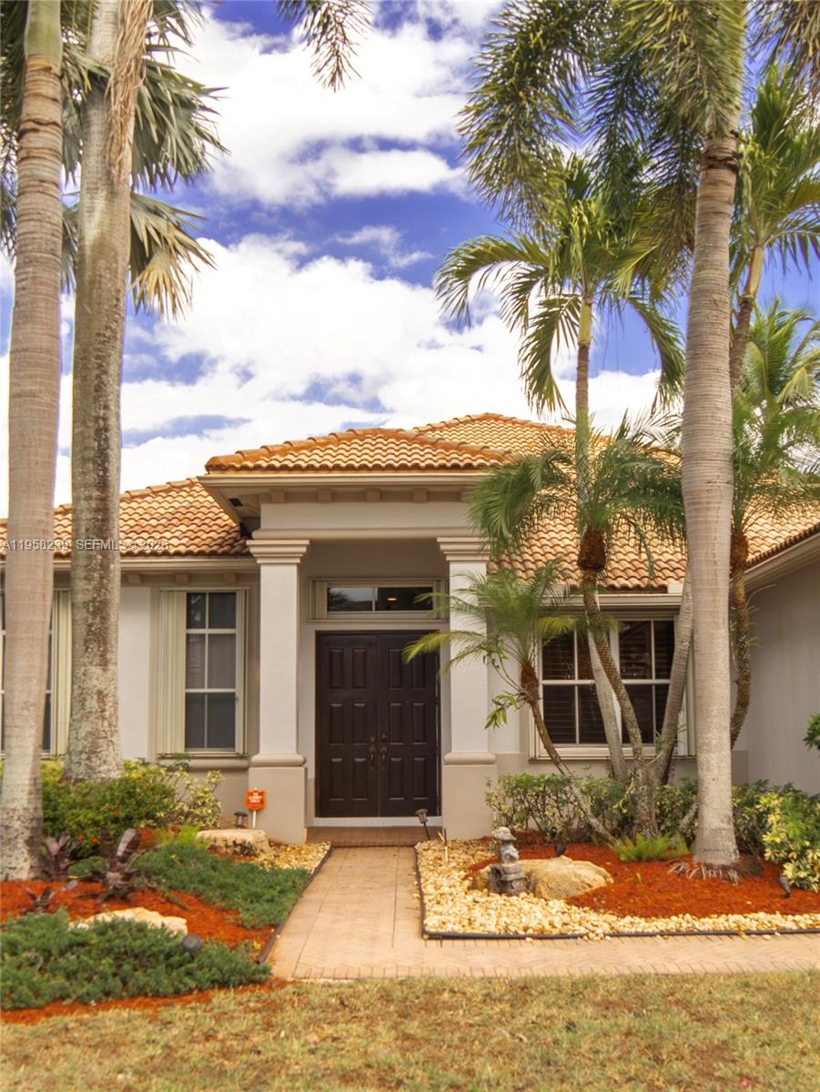 A single-story house with a tiled roof, palm trees, and a dark double-door entrance — 2288 Quail Roost Dr # 0, Weston FL 33327, WESTON, FL