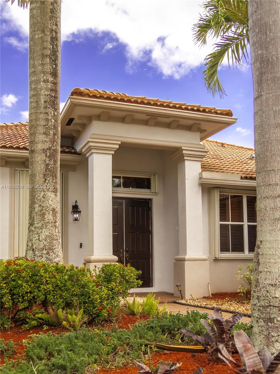 The exterior of a house features a covered entryway with columns and a tiled roof — 2288 Quail Roost Dr # 0, Weston FL 33327, WESTON, FL