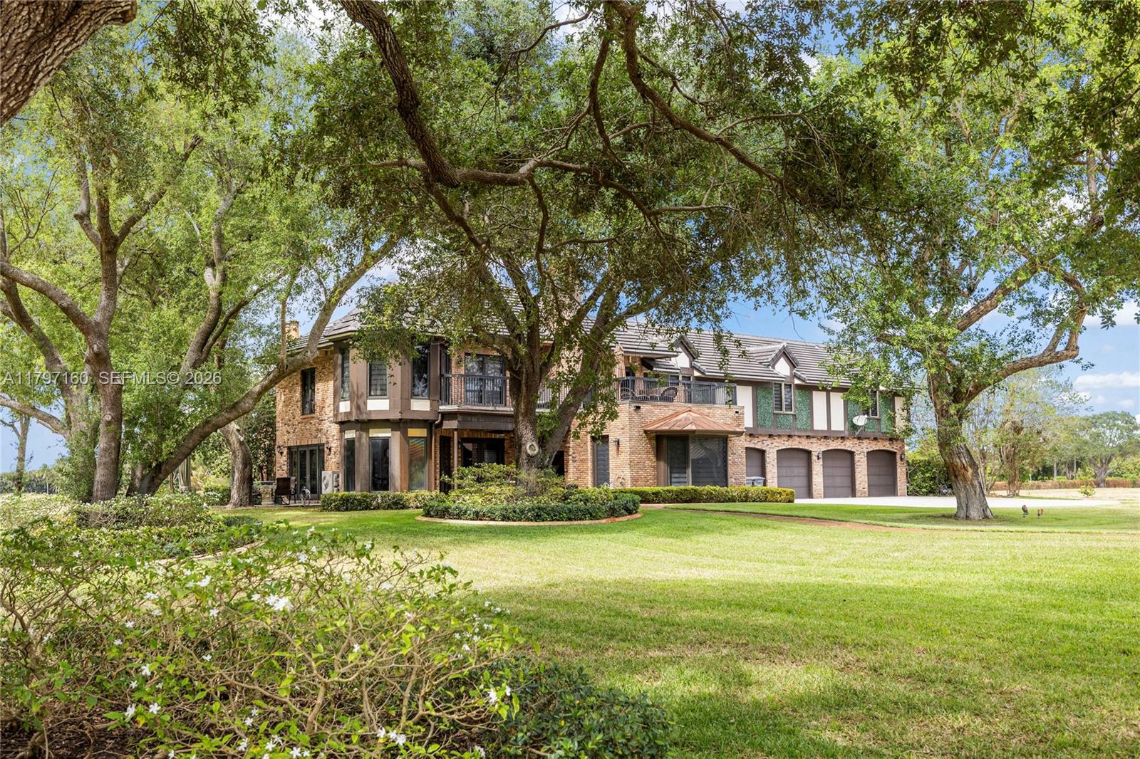A large brick two-story house with a multi-car garage sits on a grassy lawn — 8700 Surrey Ln, Boca Raton FL 33496, BOCA RATON, FL