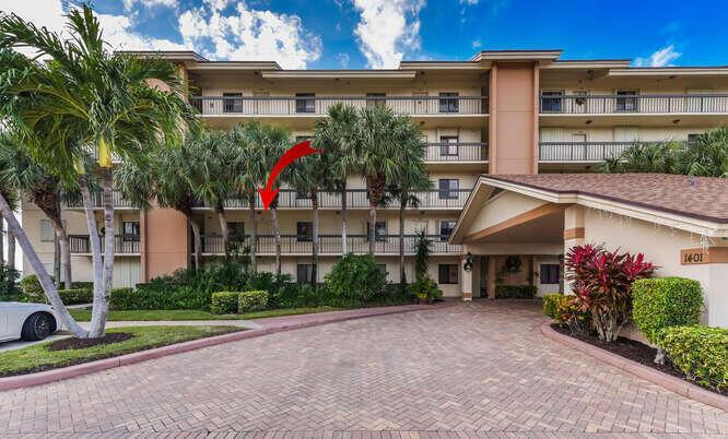 Exterior view of a multi-story apartment building with a paved driveway and palm trees — 1401 Tidal Pointe Boulevard # 202, Jupiter FL 33477, JUPITER, FL