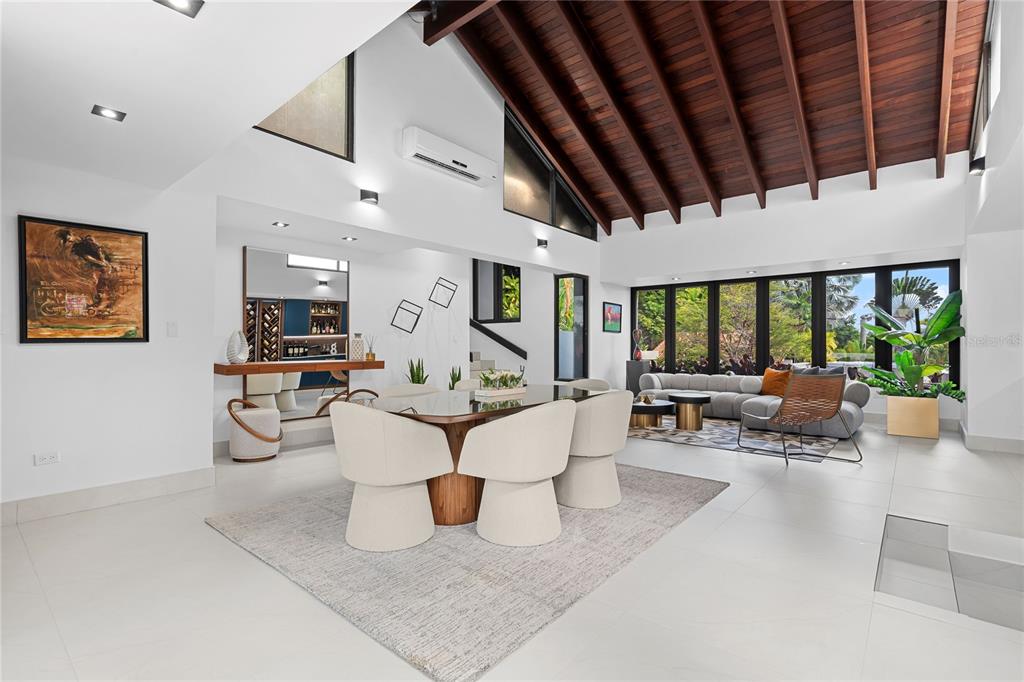 A bright, open-concept dining and living area features a vaulted wood-beamed ceiling and tile floors — 58 C, GUAYNABO, PR