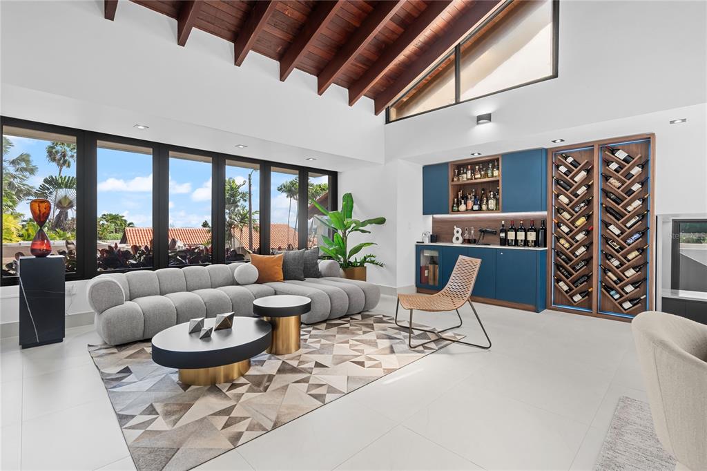 A modern living room features a grey sectional sofa, a wine bar, and vaulted ceilings — 58 C, GUAYNABO, PR