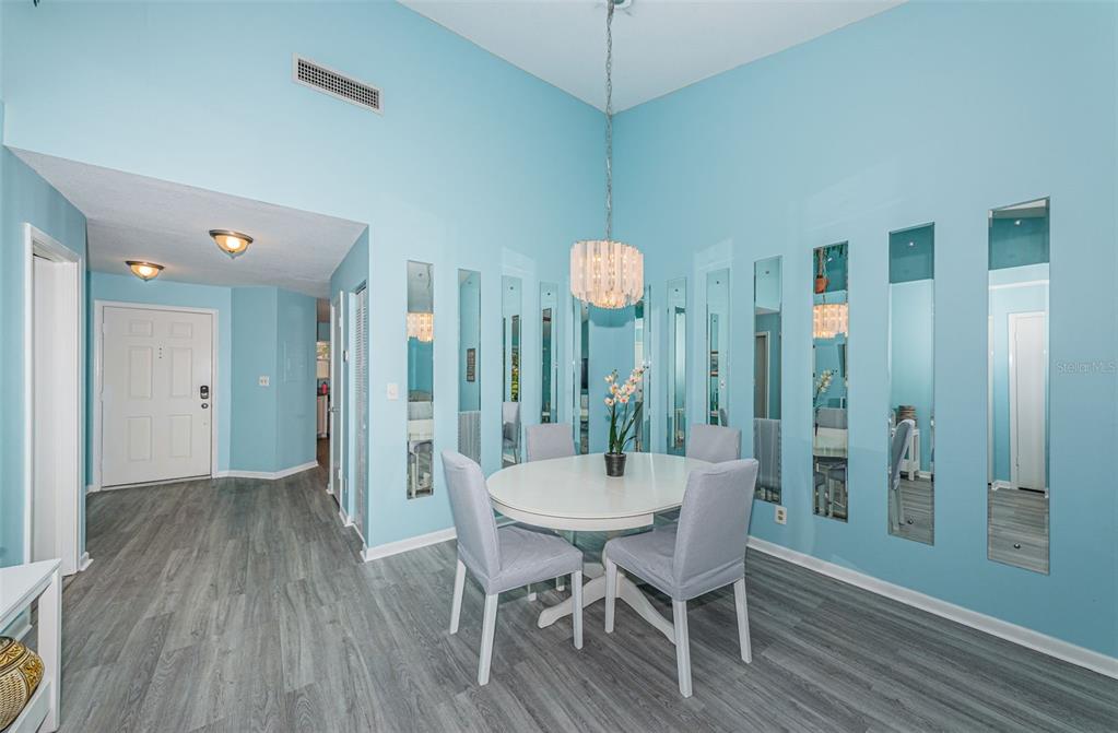 A dining area features light blue walls, vertical wall mirrors, a round table, and gray chairs — 6077 BAHIA DEL MAR BOULEVARD UNIT 224, ST PETERSBURG, FL