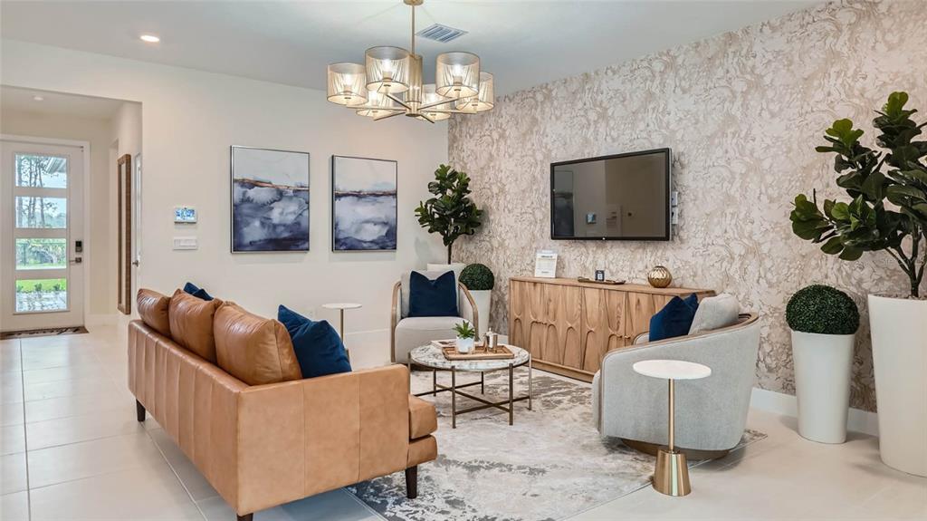 A living room features a leather sofa, two armchairs, a television, and patterned wallpaper — 7349 SW 45TH COURT, OCALA, FL