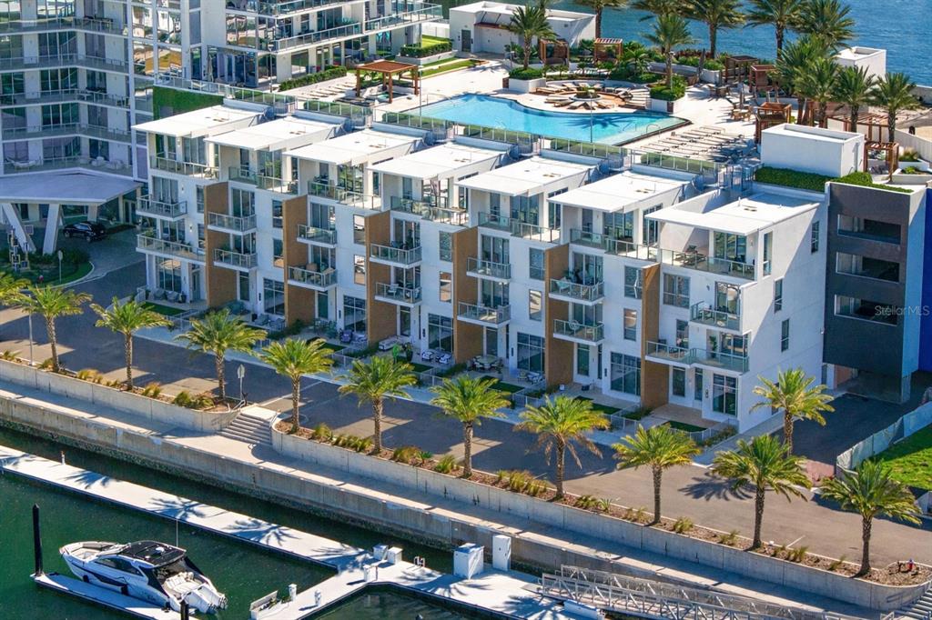 An aerial view of a modern multi-story apartment complex with a pool and boat docks — 5142 MARINA WAY, TAMPA, FL