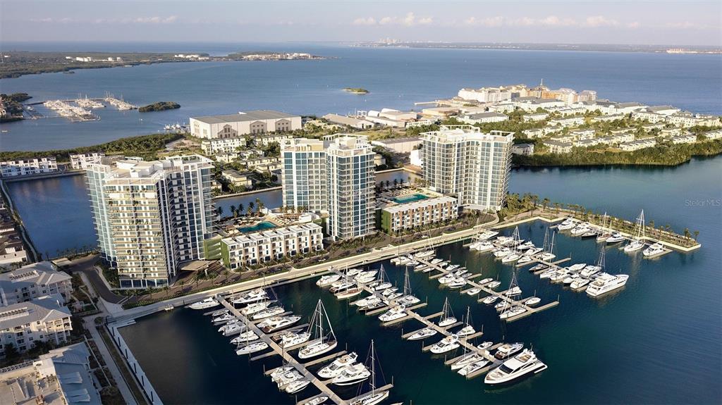 An aerial view shows high-rise apartment buildings situated next to a marina filled with boats — 5142 MARINA WAY, TAMPA, FL