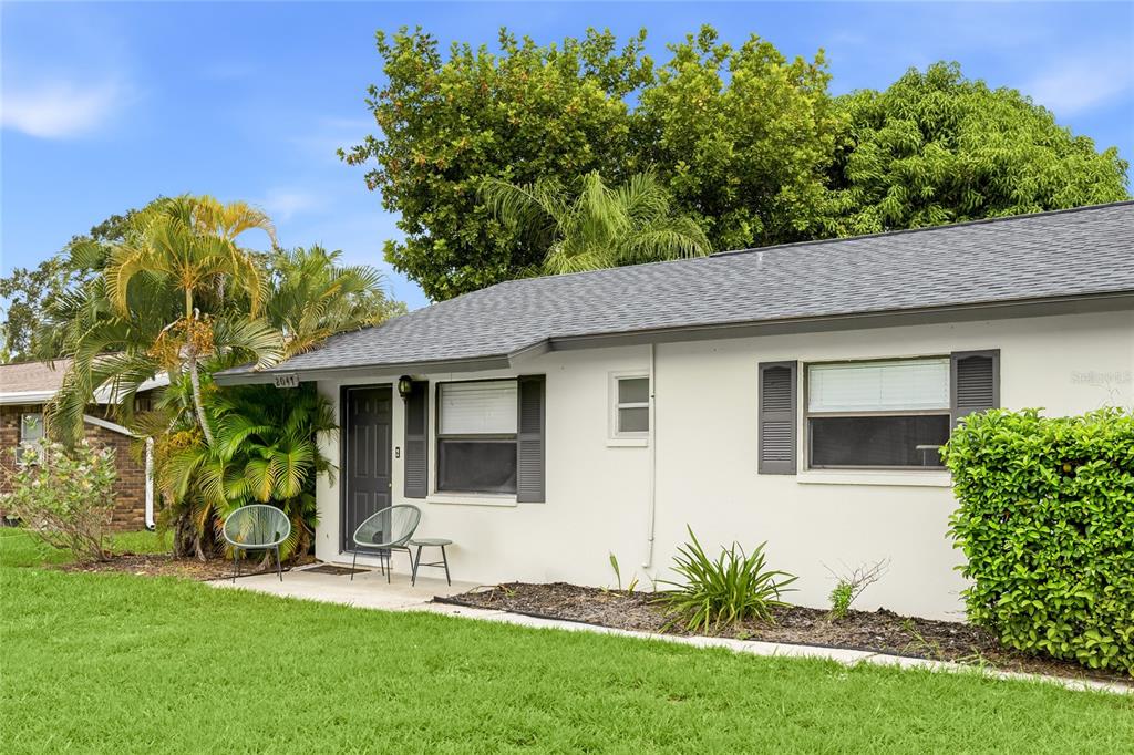 A single-story house with a white exterior, gray shutters, and a small front patio — 2047 & 2051 FIESTA DRIVE, SARASOTA, FL