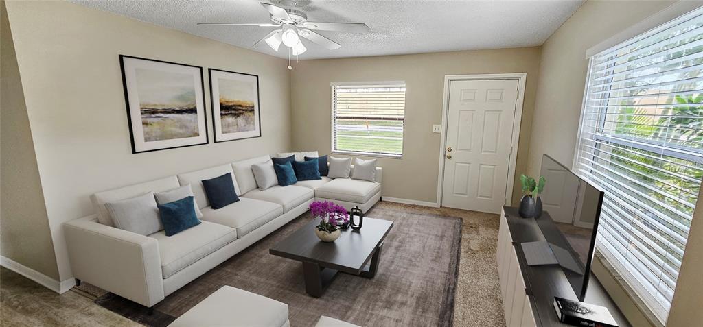 A living room features a white sectional sofa, a dark coffee table, and a television — 2047 & 2051 FIESTA DRIVE, SARASOTA, FL