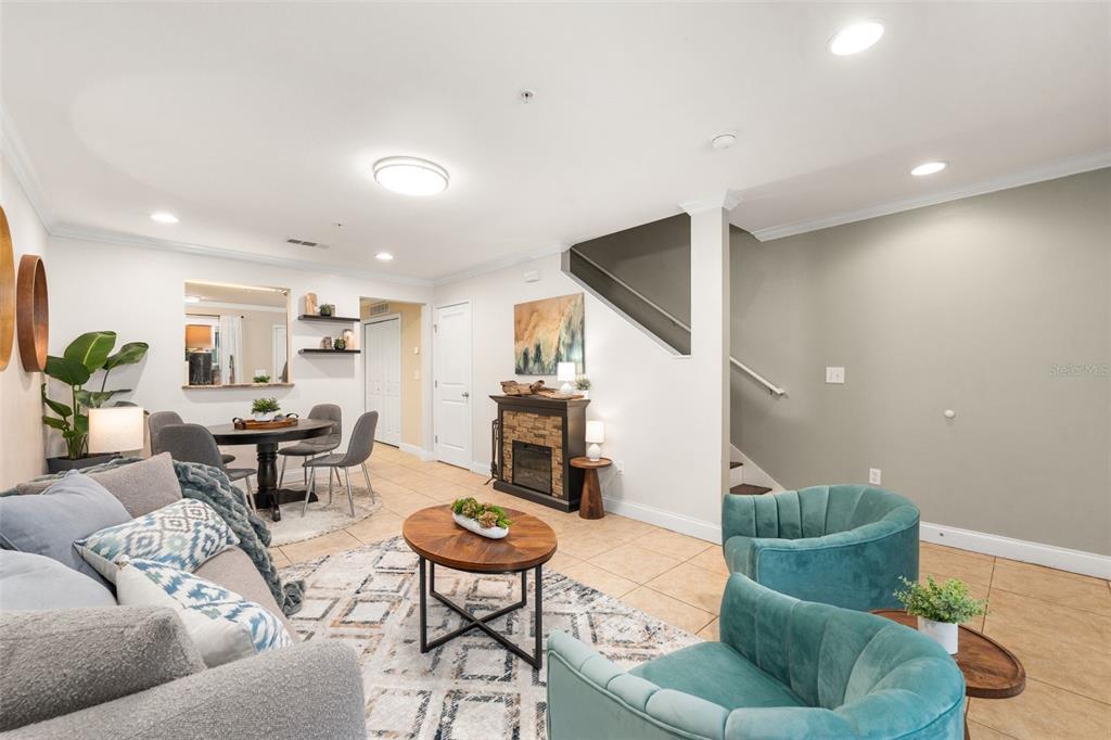 A living room with teal armchairs, a sofa, and a staircase on the right — 4639 SW 48TH DRIVE UNIT 151, GAINESVILLE, FL