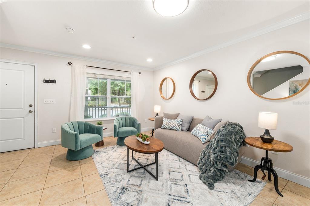 A living and dining area features tile flooring, a round table, and a gray sofa — 4639 SW 48TH DRIVE UNIT 151, GAINESVILLE, FL