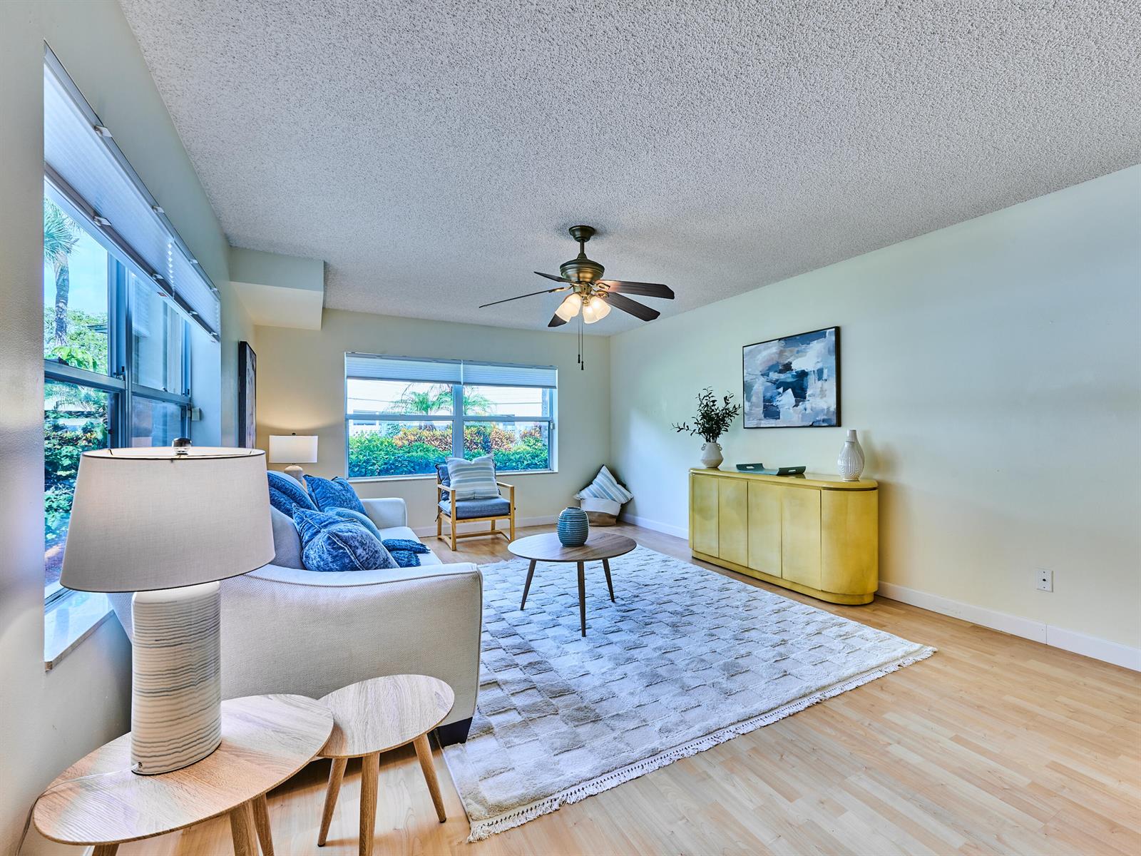 A living room features a light-colored sofa, a yellow sideboard, and a patterned area rug — 4604 Roxbury Court, Boynton Beach FL 33436, BOYNTON BEACH, FL