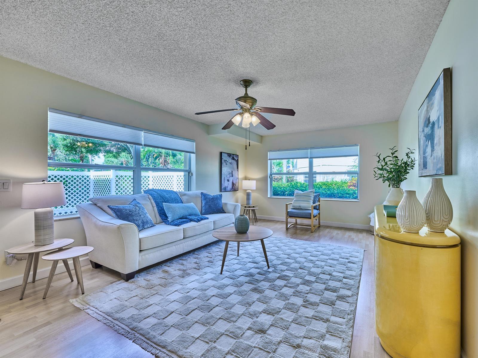 A living room features a white sofa, a textured area rug, and a yellow cabinet — 4604 Roxbury Court, Boynton Beach FL 33436, BOYNTON BEACH, FL