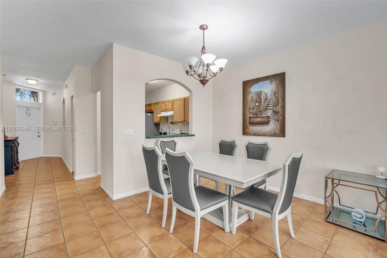 A dining area features a white table, six gray chairs, and a kitchen pass-through window — 4266 SW 10th Pl, Deerfield Beach FL 33442, DEERFIELD BEACH, FL