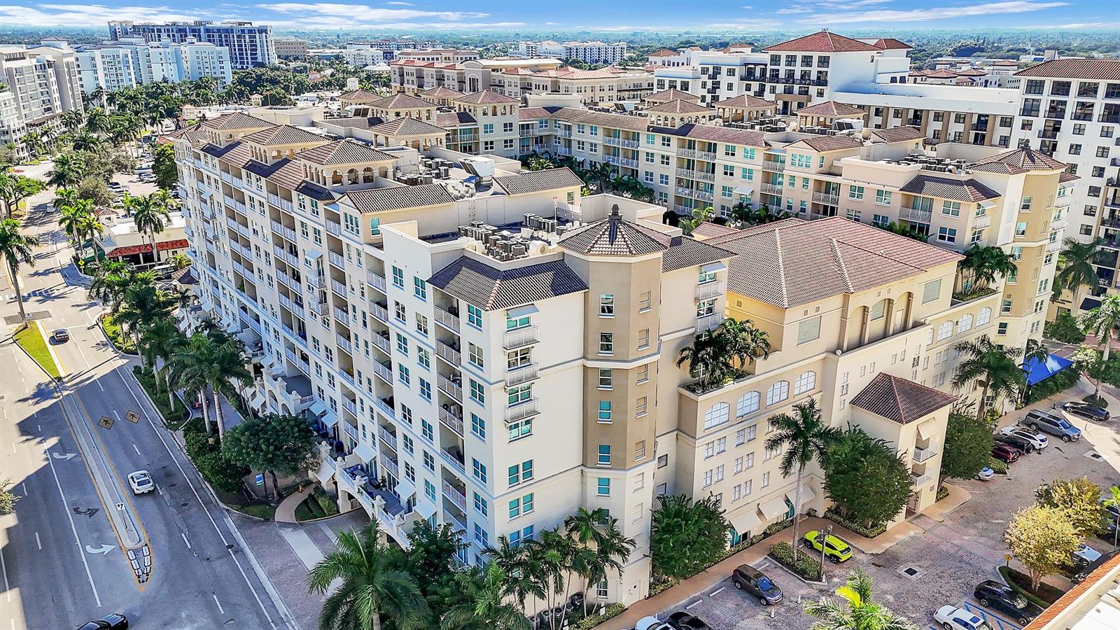 An aerial view shows a large, multi-story apartment complex with a tiled roof and balconies — 99 SE Mizner Boulevard # 40, Boca Raton FL 33432, BOCA RATON, FL