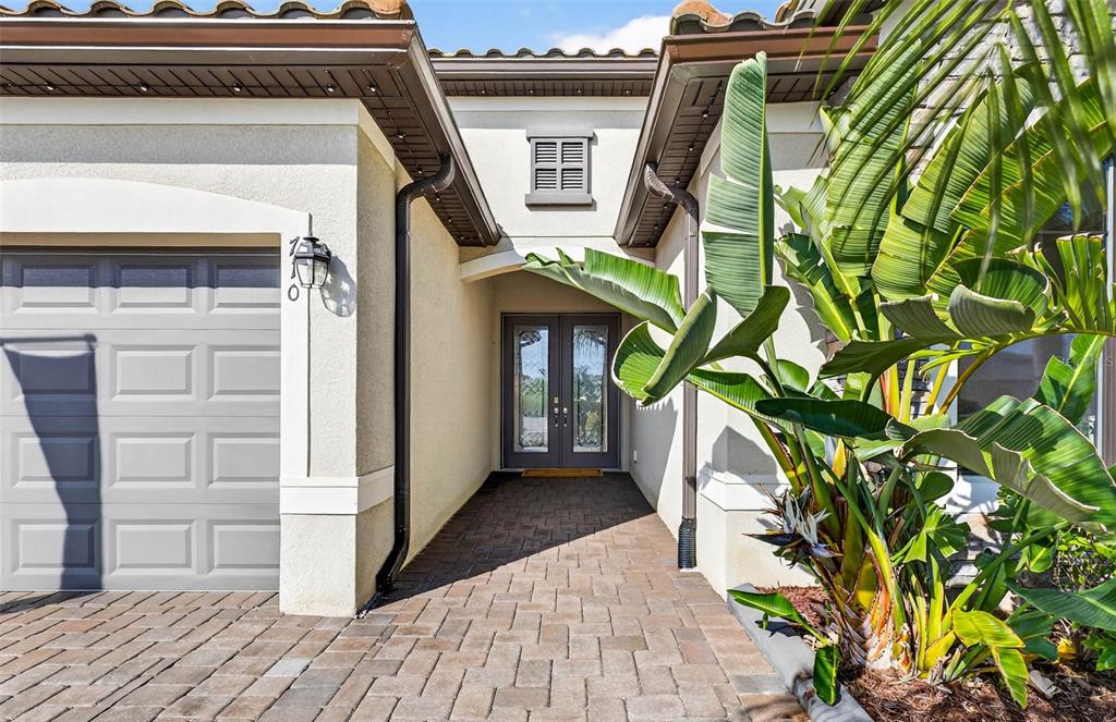 A paved walkway leads to the double front doors of a house with a garage — 710 ACACIA COURT, BRADENTON, FL