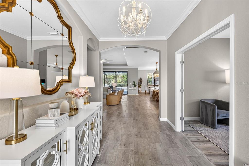 A bright foyer with a white console table leads into an open-concept living area — 710 ACACIA COURT, BRADENTON, FL