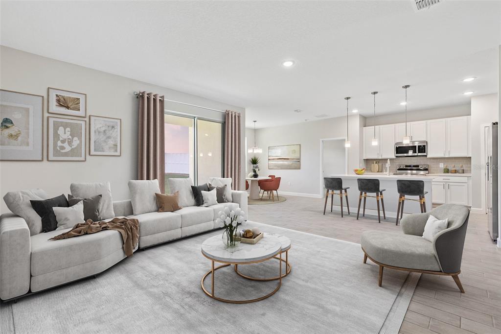 An open-concept living room and kitchen feature light-colored furniture, tile flooring, and a sliding door — 17 EL DORADO BOULEVARD N, CAPE CORAL, FL