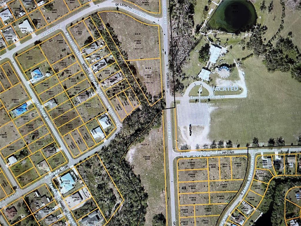 This is an aerial map showing residential lots, streets, and a large vacant area — LOT 11 BARCELONA STREET, NORTH PORT, FL