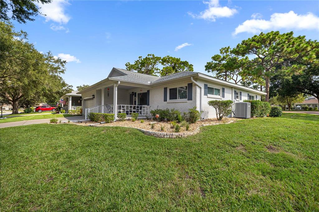 A single-story white brick house with a covered front porch and a landscaped lawn — 9920 SW 89TH COURT ROAD UNIT F, OCALA, FL
