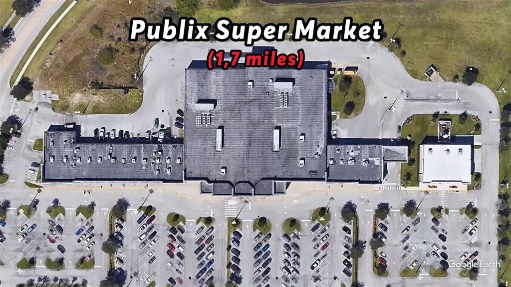 This aerial view shows a large commercial building with a parking lot and surrounding grounds — 2772 FIELDS AVENUE SE, PALM BAY, FL