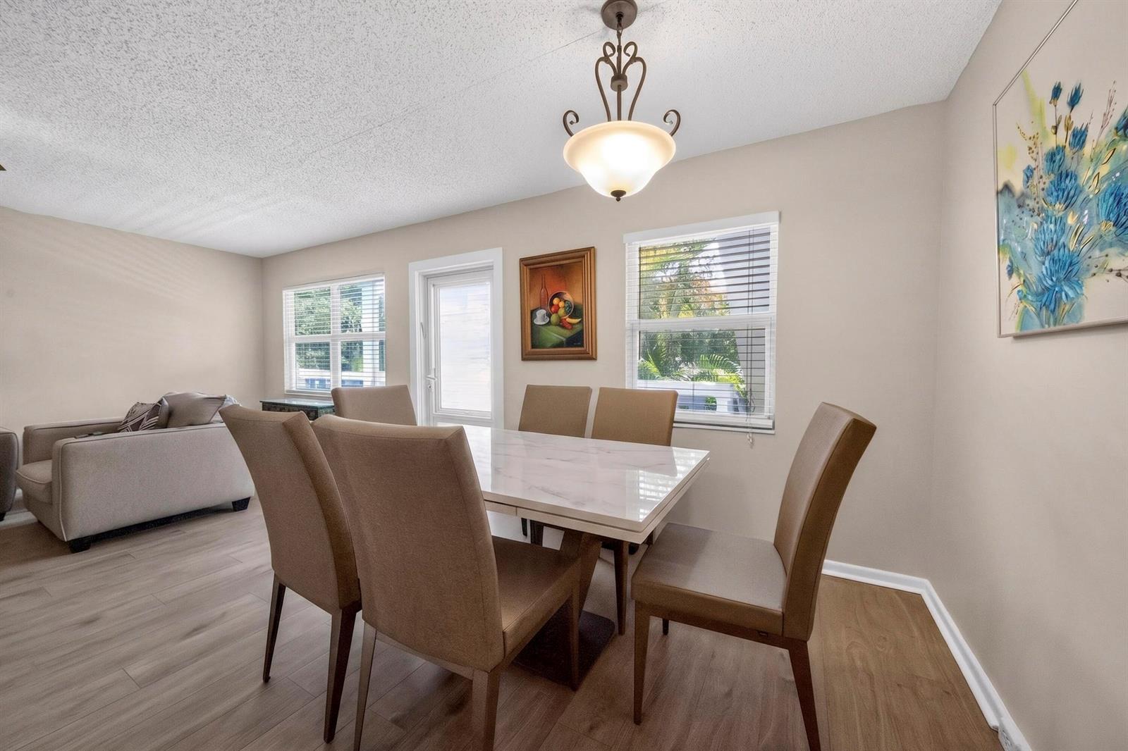 A dining room features a marble-topped table, six chairs, a chandelier, and light-colored flooring — 2002 Berkshire A # 2002, Deerfield Beach FL 33442, DEERFIELD BEACH, FL