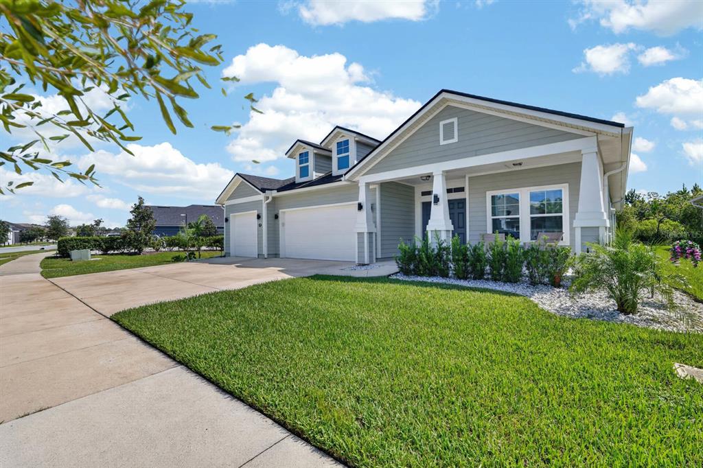 A light green single-story house with a three-car garage and a covered front porch — 473 GRAND LANDINGS PARKWAY, PALM COAST, FL