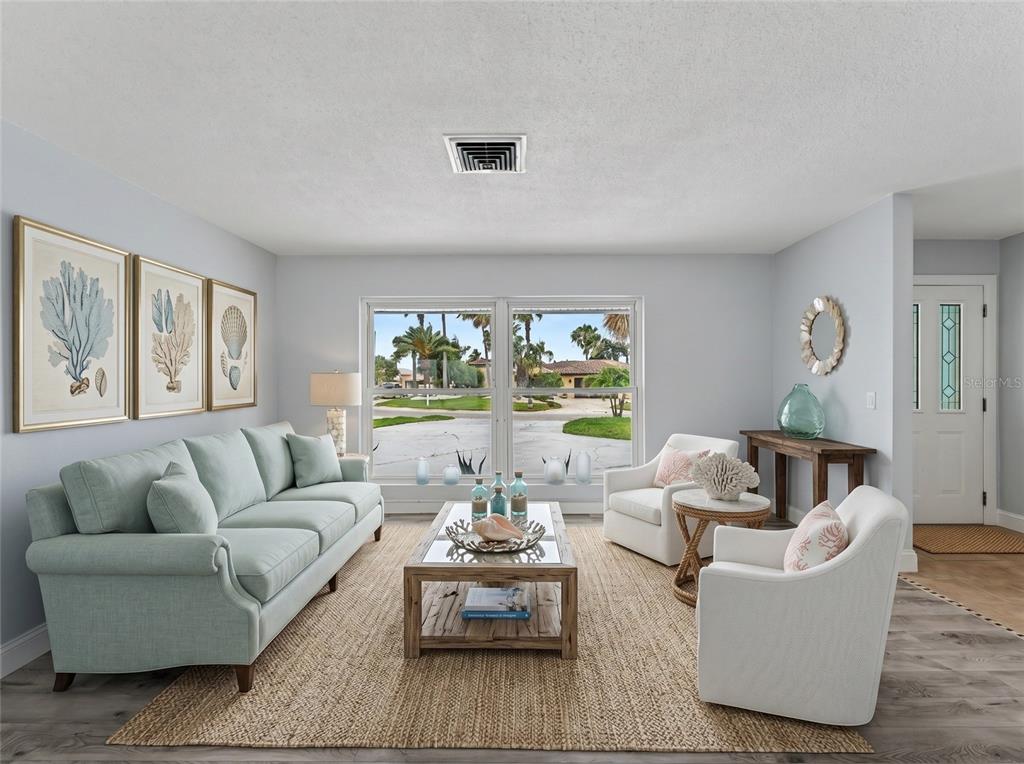 A living room features a light blue sofa, two white armchairs, and a large window — 4956 GALLEON COURT, NEW PORT RICHEY, FL