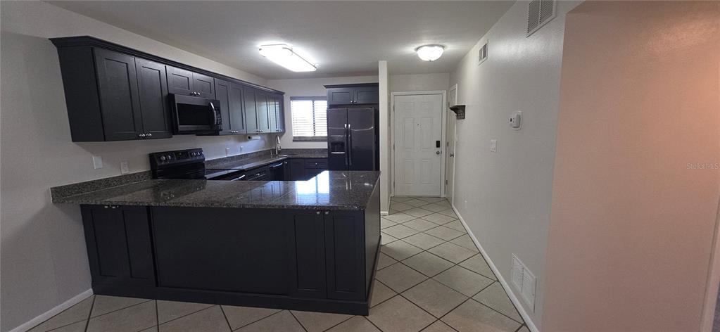 A two-story blue apartment building with exterior staircases and a paved parking lot in front — 6033 34TH STREET W UNIT 136, BRADENTON, FL