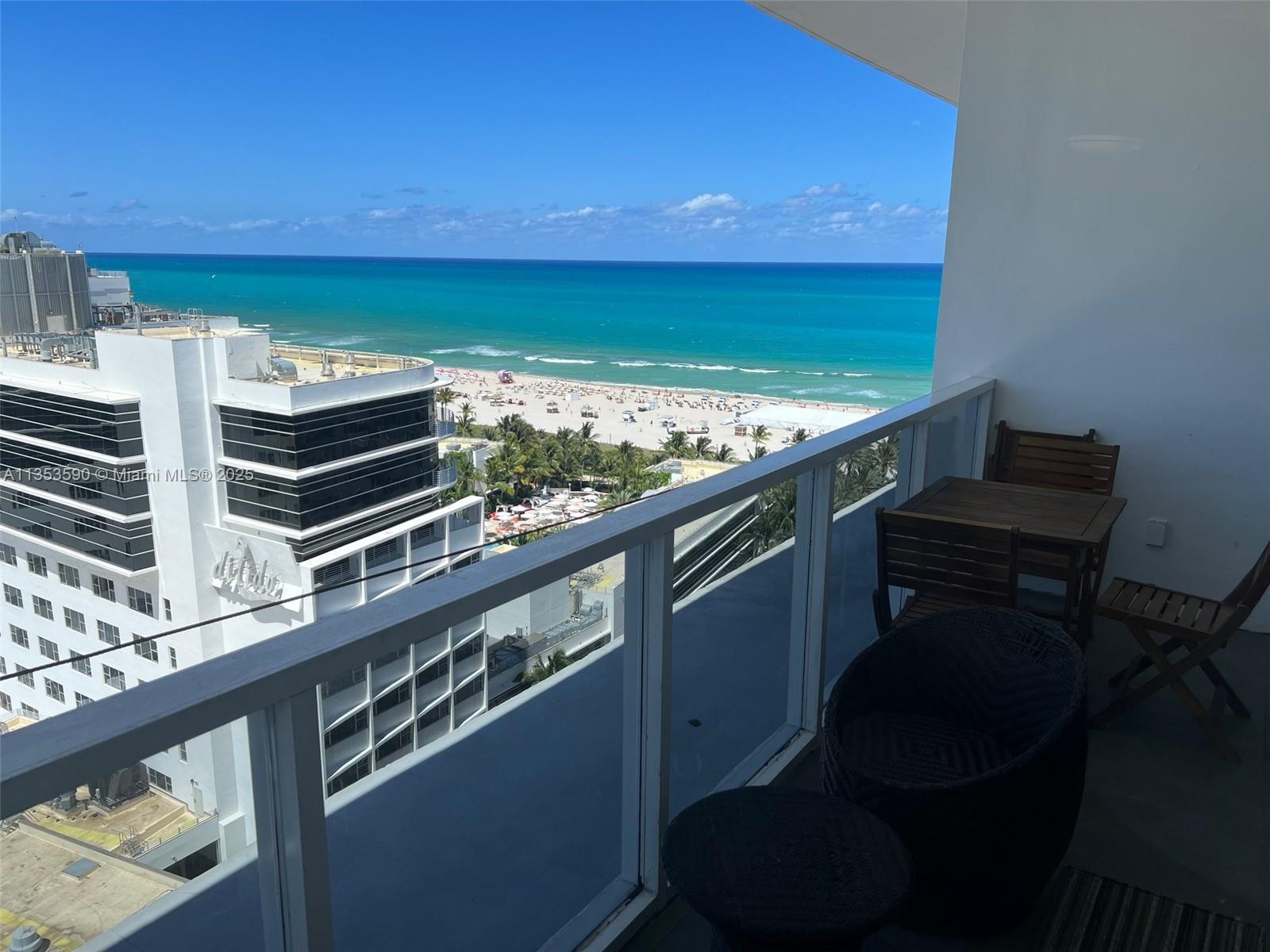 A balcony with outdoor furniture overlooks a beach and the ocean — 100 Lincoln Rd, Miami Beach FL 33139, MIAMI BEACH, FL