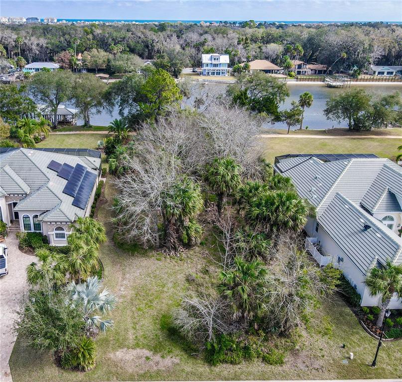 An aerial view shows a vacant lot situated between two houses near a waterfront — 121 LONGVIEW WAY N, PALM COAST, FL